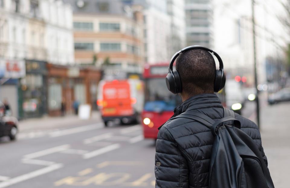 A traveller with headphones and a backpack